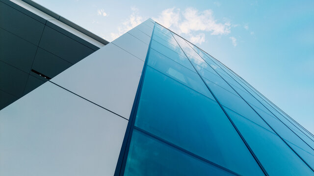 Low angle shot of modern glass city buildings with clear sky background.