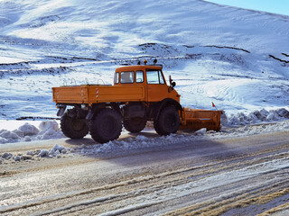 snowplough shovel machin cleaning the road from snow and  ice in winter