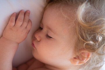 Cute baby child sleeping in the bed. Closeup sleepy kids face.