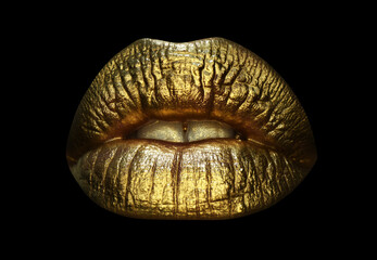 Gold lips, golden gloss lipstick. Luxury gold lips make-up. Golden lips with golden lipstick. Gold paint on lips of sexy girl. Sensual woman mouth, isolated background.