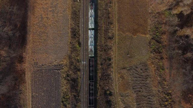 Locomotive pulls railway freight train with wagons filled coal Top View of train