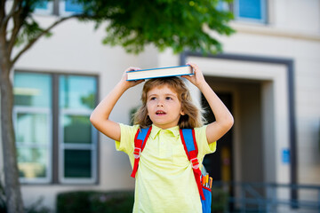 Happy smiling kid in glasses is going to school for the first time. Pupil go study. Child boy with...