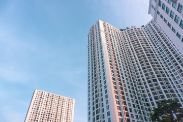 Fototapeta na wymiar High-rise apartment buildings in the city center. Low angle shot of modern architecture in the blue sky. Futuristic cityscape view 