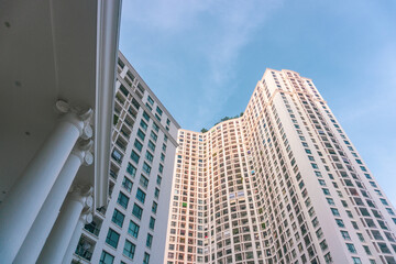 Fototapeta na wymiar High-rise apartment buildings in the city center. Low angle shot of modern architecture in the blue sky. Futuristic cityscape view 