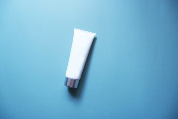 White squeeze bottle plastic tube on blue background. spa & cosmetics concept, flatlay, top view. Mockup, template.