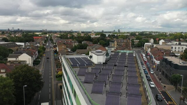 corner building with solar collectors on flat root and crossroad in front of. London, UK