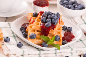 Waffles with blueberries and jam. 