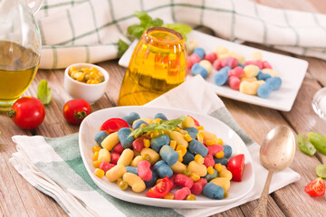 Colored gnocchi with vegetables and sweet corn.