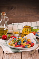 Colored gnocchi with vegetables and sweet corn.