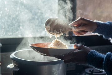 selective focus,soft focus Women hand holding and using wood ladle to scoop steamed rice from...