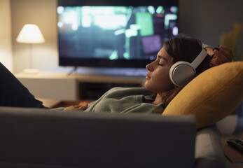 Teenager relaxing on the sofa and listening to music