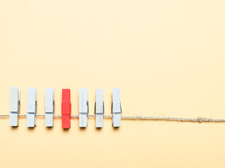 A row of clothes peg with single red color. Concept of individuality and virus infected.