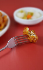 Half eaten piece of grilled boneless chicken with garlic flavour on a fork