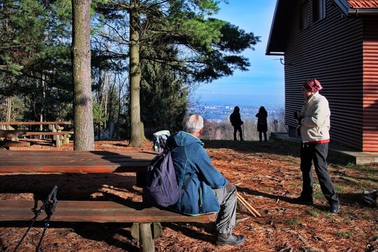 Senior couple resting on a bench after hiking - Powered by Adobe