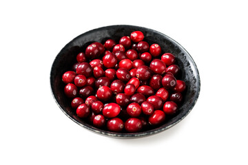 Cranberries in black bowl isolated on white background.