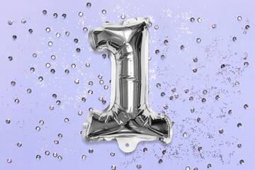 Silver foil balloon number, digit one on a lilac background with sequins. Birthday greeting card...