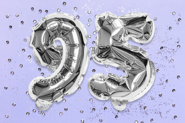 Silver foil balloon number, digit ninety five on a lilac background with sequins. Birthday greeting...