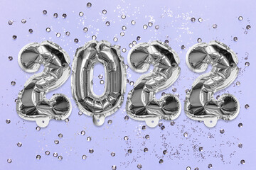 Silver foil balloon number, digit 2022 on a lilac background with sequins. New Year's card. Happy new year celebration party. Greetings and congratulation concept.