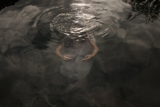 Fine art portait of girl in dress floating underwater in the water