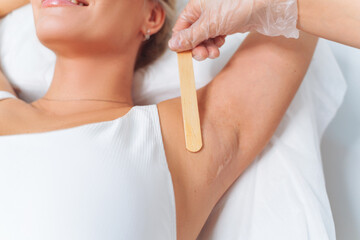 Laser epilation and cosmetology in beauty salon. Laser hair removal. Woman during laser hair removal procedure. Applying conductive gel. Armpit epilation