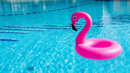 Gardinen Flamingo tropical. Pink inflatable flamingo in water for summer beach background. Pool float party. © Maksym