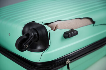A close-up of a broken plastic suitcase.