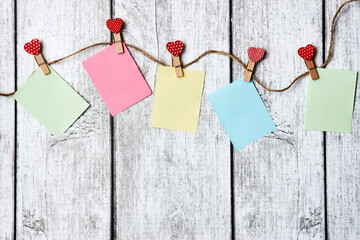 Red hearts on rope with clothespins and note paper