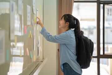 A female student looking at the notice posted on the board