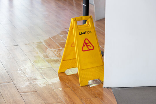 Wet Floor Sign With Water Drops On Wet Stone Floor In Restaurant.