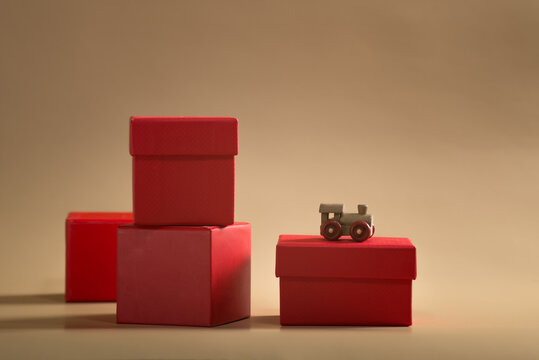 small wooden train with red boxes of gifts on a beige background