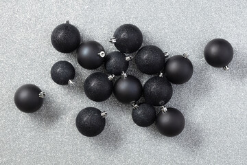 Black Christmas toys or decor on a gray background with copy space