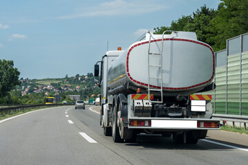 Cistern tank truck on a highway under the blue clear sky
