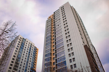 Fototapeta na wymiar Chelyabinsk, Russia - December 2021: Modern high-rise buildings against the sky with clouds. Bottom up view.