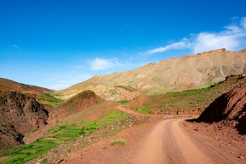 In the Atlas Mountains in Morocco. A dirt track plunges into the mountains towards the Tizi N Tighist pass in the Ait Boulli valley