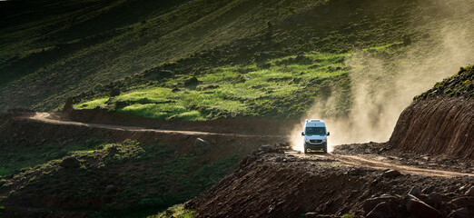 In the Atlas Mountains in Morocco. A 4x4 van lifts a cloud of dust on the dirt road that climbs towards the Tizi N’Tighist in the Ait Boulli valley © Louis-Michel DESERT