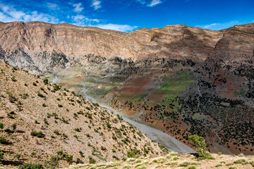 In the Atlas Mountains in Morocco. Color play between rock and vegetation in an arid valley.