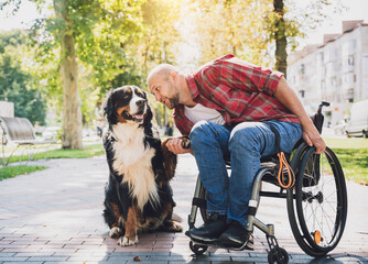 Happy young man with a physical disability in a wheelchair with his dog.