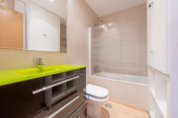 Fototapeta na wymiar Toilet with black cabinet and green glass sink in a vacation rental apartment