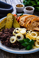 Fried blood sausage with onion and toasted bread on wooden table

