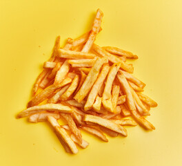  Bunch of french fried potatoes over yellow background