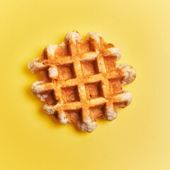  Single delicious waffle over yellow background