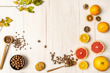 Decorative frame with citrus fruits, chocolate cookies, chocolates and coffee on light wooden table
