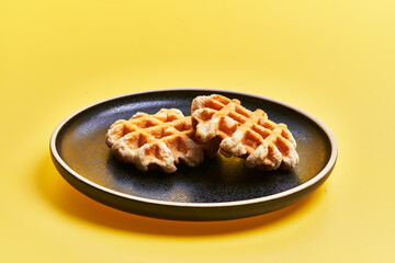 Plate of delicious waffles over yellow background