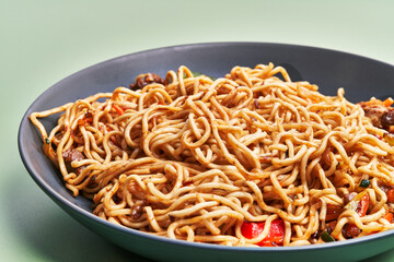  Plate of delicious noodles over green background