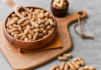 Image of wooden spoons with peanuts on a concrete surface