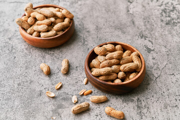 Image of bunch of peanuts in a bowl on a concrete surface