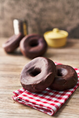 Fototapeta na wymiar Bunch of chocolate doughnuts on a wooden surface