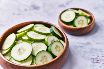  Bowls of slices of cucumber on a marble surface