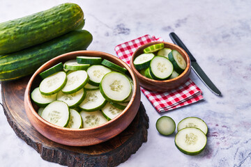  Bowl of slices of cucumber on a marble surface