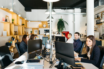 People sharing office and working on a desk with computers